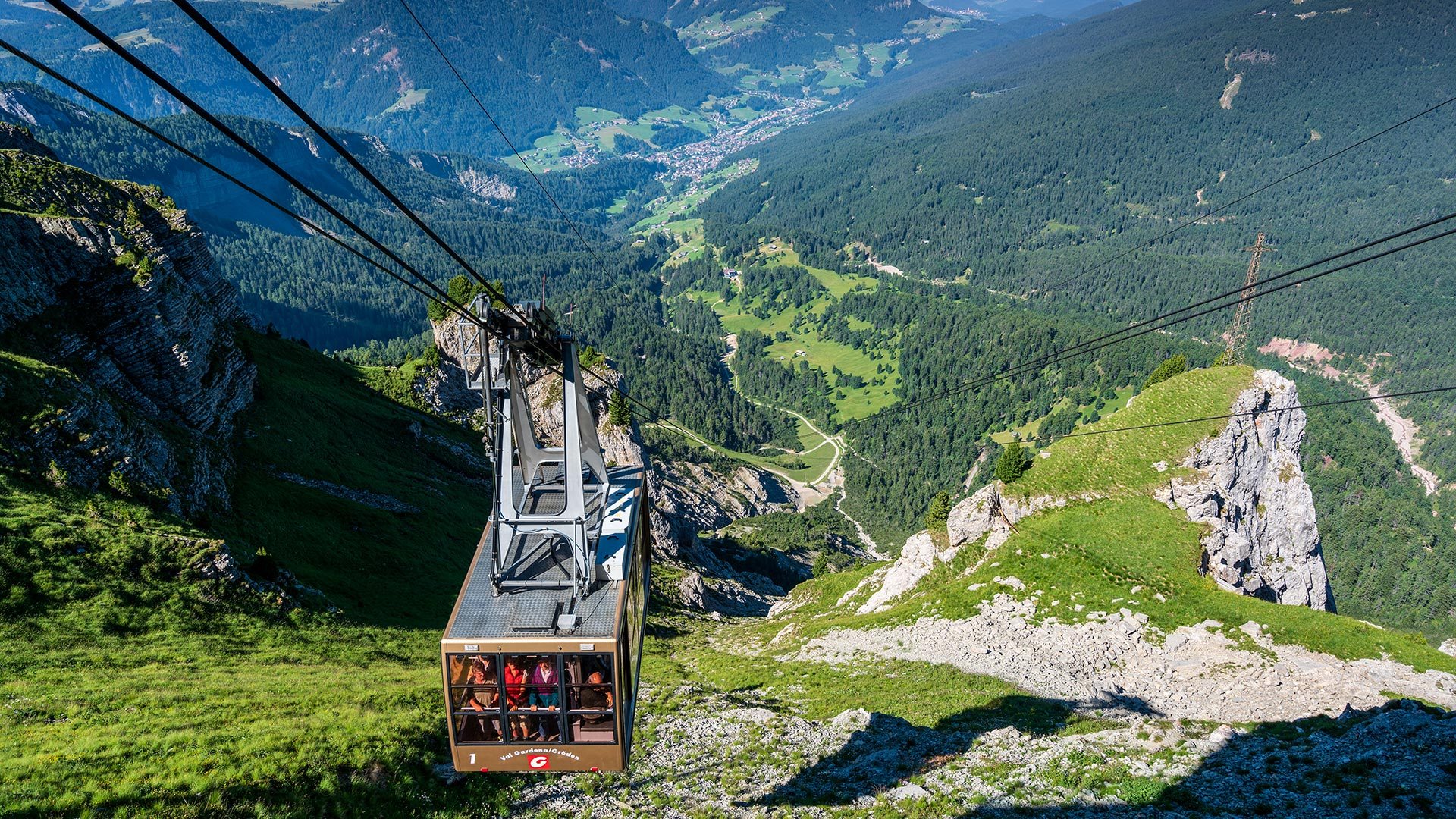 Gondol over grønne fjellsider i Val Gardena