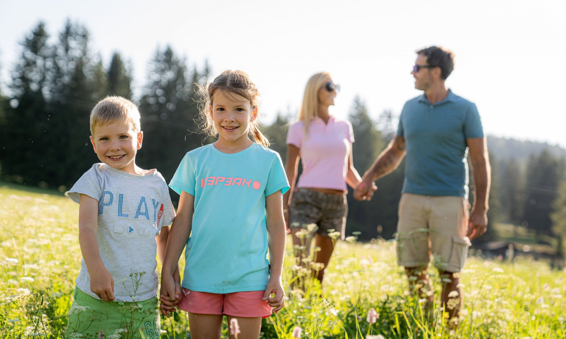 Familie på tur i blomstereng på Monte Pana