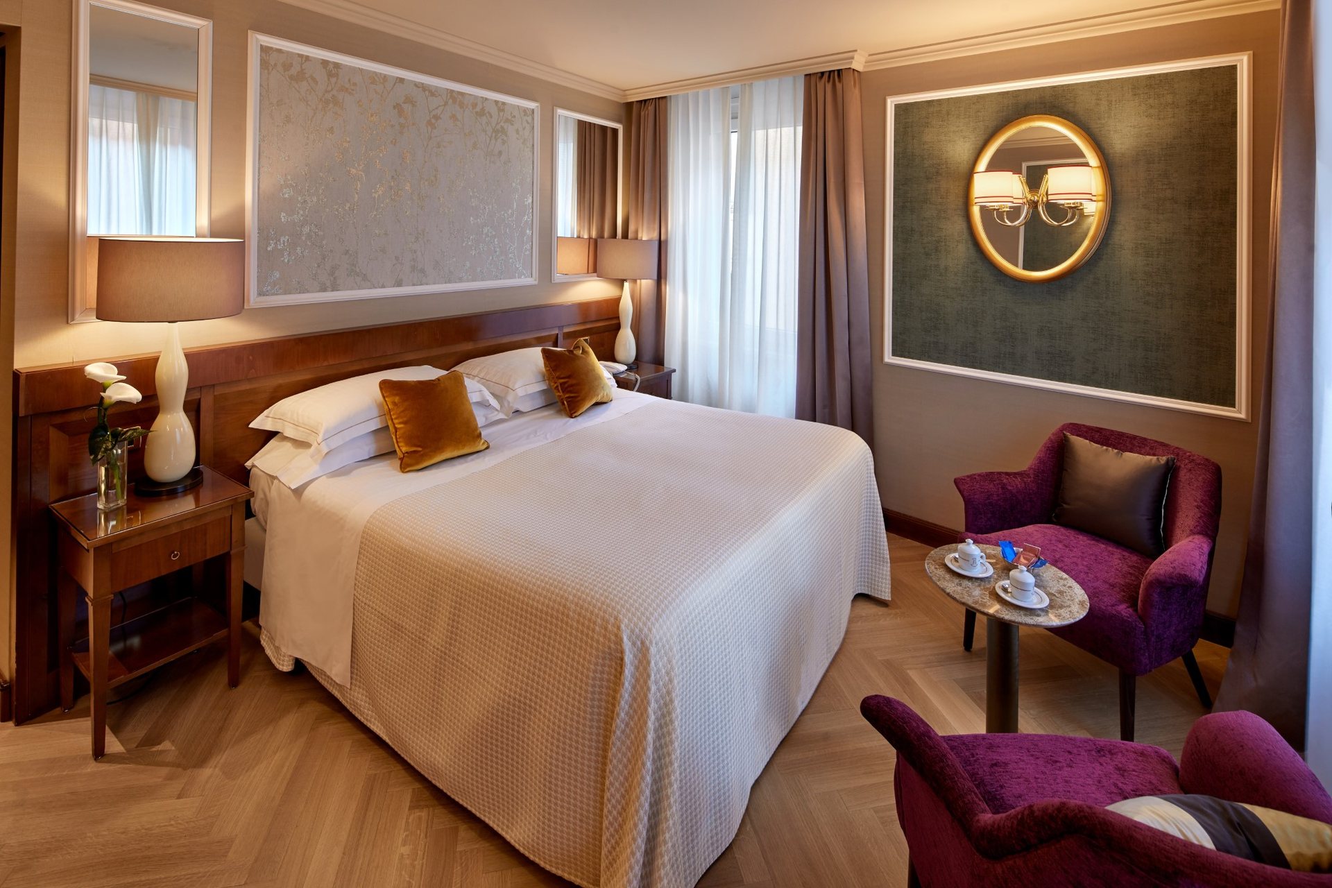 Elegant hotellrom i kremtoner med høye vinduer